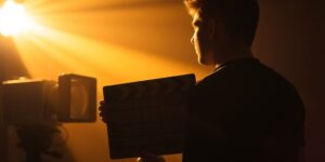 Filmmaker holding a clapperboard with projector light.