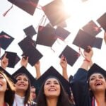 Graduates celebrating with diplomas in hand.