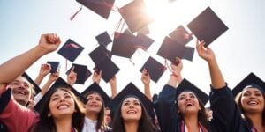 Graduates celebrating with diplomas in hand.