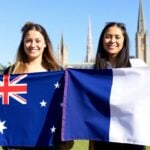 Australian and French students holding flags on campus