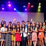 Diverse Hispanic youth celebrating on colorful awards stage