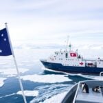 Australian and French flags on ship in Antarctic ice